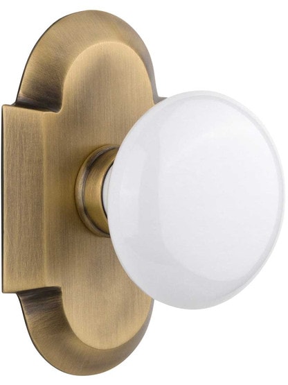 Arched Rosette Door Set with White Porcelain Knobs in Antique Brass.